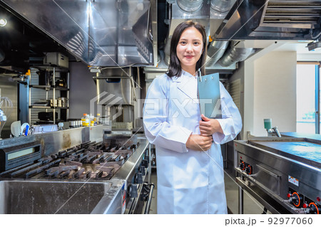 レストラン厨房で白衣を着た女性 92977060