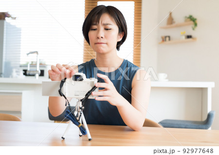 カメラを操作に悩む女性 カメラを操作に悩む女性 92977648