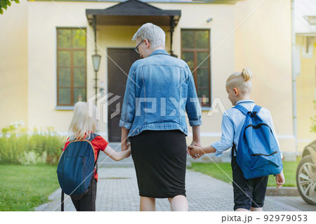 mother accompanies children to school holding hands. 92979053