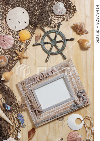 Empty Frame on Wooden Background With Sea Shells and Fishing Net. Nautical and Coastal Theme Empty Frame on Wooden Background With Sea Shells and Fishing Net. Nautical and Coastal Theme 92979414