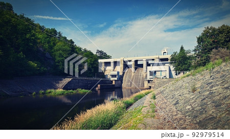 A dam on the Brno Reservoir by the Svratka River with a small power plant. Beautiful sunny summer day in nature. A dam on the Brno Reservoir by the Svratka River with a small power plant. Beautiful sunny summer day in nature. 92979514