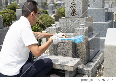 お墓参りに来てお墓の掃除をしているシニア男性 お墓参りに来てお墓の掃除をしているシニア男性 92981717