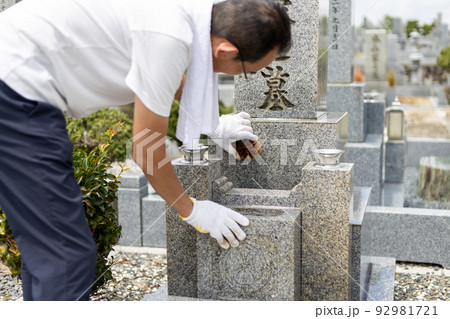 お墓参りに来てお墓の掃除をしているシニア男性 お墓参りに来てお墓の掃除をしているシニア男性 92981721