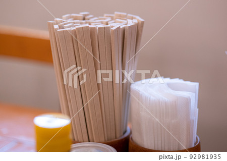Close up of Chinese casual restaurant table setting of chopsticks, sauces, toothpicks and bottles of seasonings. 92981935