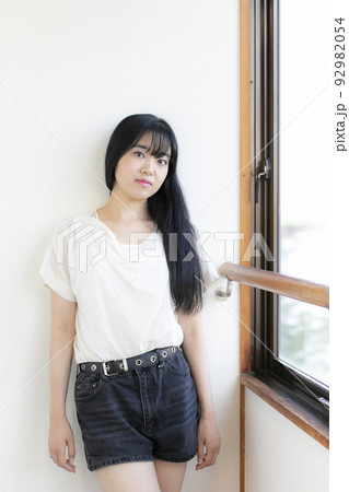 窓際に立つミニスカートの若い女性 窓際に立つミニスカートの若い女性 92982054
