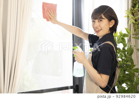 窓を拭くハウスクリーニングの女性作業員 窓を拭くハウスクリーニングの女性作業員 92984620