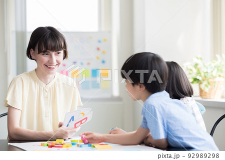 教育　英会話教室でレッスンを受ける子供とネイティブ講師 92989298