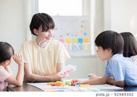 教育　英会話教室でレッスンを受ける子供とネイティブ講師 92989302