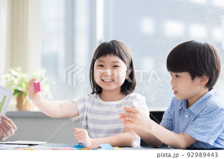 教育　英会話教室でレッスンを受ける子供とネイティブ講師 92989443