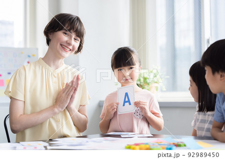 教育　英会話教室でレッスンを受ける子供とネイティブ講師 92989450