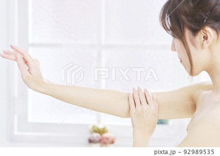 自宅で腕のケアをする女性 自宅で腕のケアをする女性 92989535