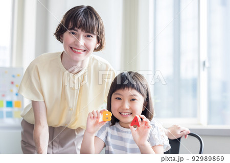 教育　英会話教室でレッスンを受ける子供とネイティブ講師 92989869