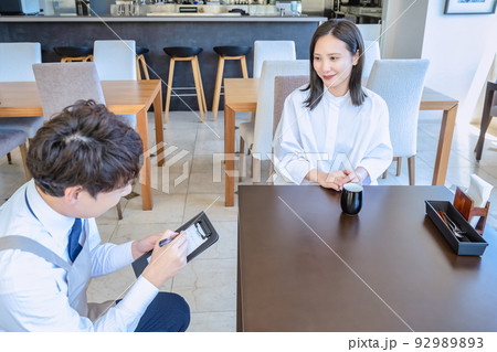 レストラン 若い女性客と注文を取る男性店員 レストラン 若い女性客と注文を取る男性店員 92989893