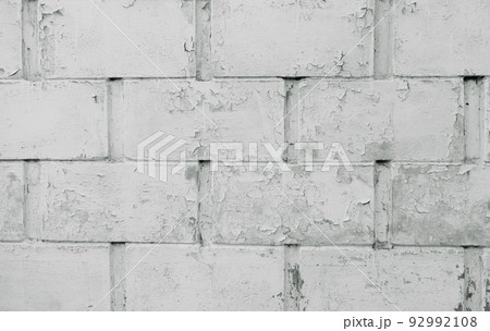 Old wall with cracked surface and unattractive gliding color, white brick background. Photo of an old white brick wall texture. The surface of the white brick wall of the house is being cleaned. Old wall with cracked surface and unattractive gliding color, white brick background. Photo of an old white brick wall texture. The surface of the white brick wall of the house is being cleaned. 92992108