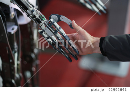Robot extends its hand to man for handshake 92992641