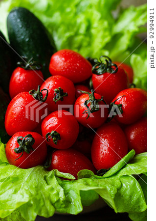Cherry tomatoes, cucumbers and green salad leaves. Fresh harvest. Cherry tomatoes, cucumbers and green salad leaves. Fresh harvest. 92994911