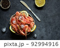 Frozen shrimps with lemon and ice on a dark background. 92994916