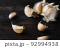 Garlic cloves on a dark wooden table. 92994938