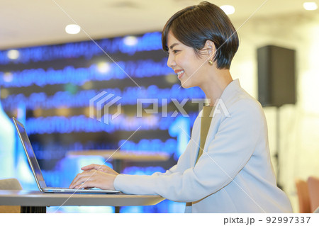 CG画面をバックに資料を作成するビジネスウーマン1 92997337