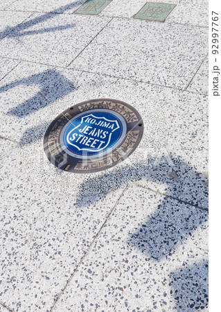 児島ジーンズストリートのマンホールとジーンズの影 92997767