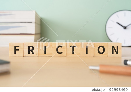 摩擦・不和・不一致のイメージ｜「FRICTION」と書かれたブロックが置かれたデスク 92998460