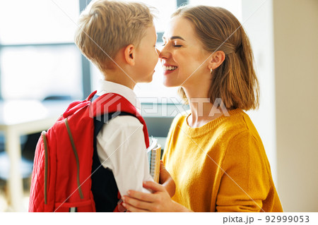 Mother preparing son for school studies Mother preparing son for school studies 92999053