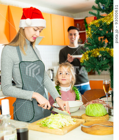 Woman with kid girl preparing family dinner 93000631