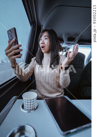 suprised young woman cover her mouth while looking at her mobile phone suprised young woman cover her mouth while looking at her mobile phone 93002215