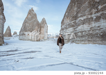 asian man walking alone in beautiful snowy landscape asian man walking alone in beautiful snowy landscape 93002244