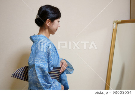 鏡の前で浴衣(絹紅梅)の着付けをする中年女性の後ろ姿 鏡の前で浴衣(絹紅梅)の着付けをする中年女性の後ろ姿 93005054
