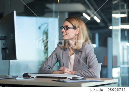 Happy and successful business woman working in the office at the computer rejoices in good results, successful employee and boss 93006755