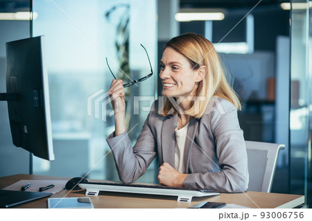 Happy and successful business woman working in the office at the computer rejoices in good results, successful employee and boss 93006756