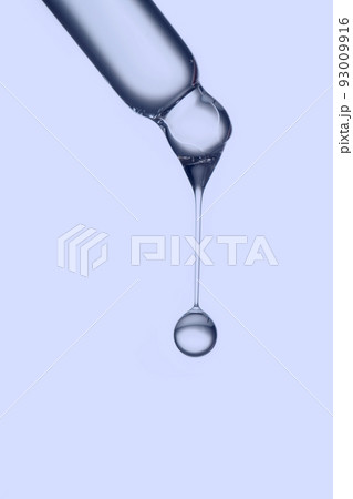 Pipette with a drop of cosmetic product on a purple background. 93009916