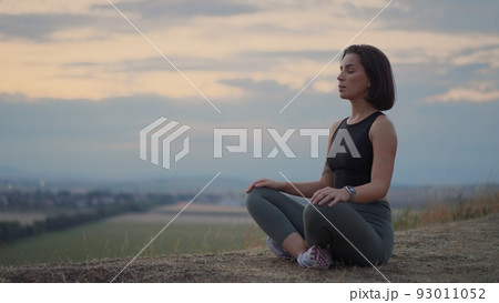 Peaceful millennial girl deeply meditating, doing breathing yoga exercises alone Peaceful millennial girl deeply meditating, doing breathing yoga exercises alone 93011052