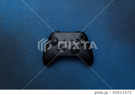 Game controller on a blue background. Black joystick for computer games top view. Game controller on a blue background. Black joystick for computer games top view. 93011475