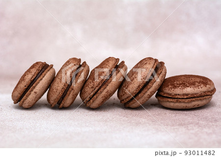 Chocolate french macaroons on a light background. Chocolate french macaroons on a light background. 93011482