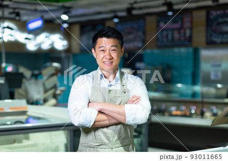 Portrait of Asian salesman in seafood and fish shop man smiling with arms crossed and looking at camera 93011665