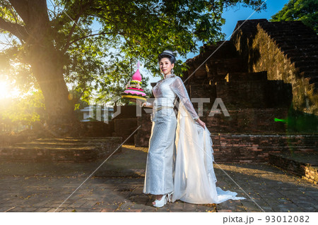 Portrait Beautiful asian woman with Thai white traditional dress costume holding Krathong and sitting in front of Pagoda temple at the ancient city Thailand,Loy Krathong Festival,Transgender model Portrait Beautiful asian woman with Thai white traditional dress costume holding Krathong and sitting in front of Pagoda temple at the ancient city Thailand,Loy Krathong Festival,Transgender model 93012082