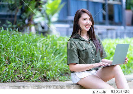 Happy of asian freelance people business female casual working with laptop computer outdoors at sunny summer day in park background,education and remote working communication concept Happy of asian freelance people business female casual working with laptop computer outdoors at sunny summer day in park background,education and remote working communication concept 93012426