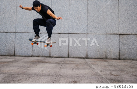 Asian woman skateboarder skateboarding in modern city Asian woman skateboarder skateboarding in modern city 93013558