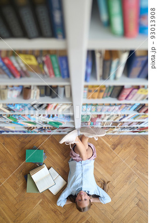 Cheerful teenage girl resting in the library Cheerful teenage girl resting in the library 93013908