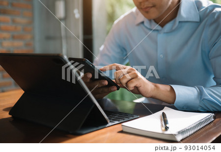 Send a message to a colleague, a businessman, confident in matching a tablet and sitting in office. Send a message to a colleague, a businessman, confident in matching a tablet and sitting in office. 93014054