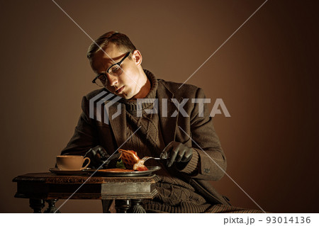 Retro style portrait of young man, writer and traveler wearing vintage style clothes isolated over dark brown background. Business, art, fashion concept 93014136