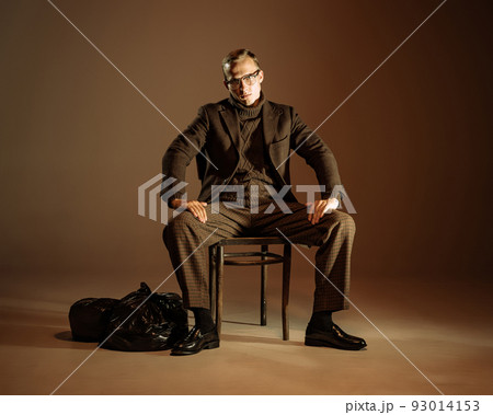 Retro style portrait of young man, writer and traveler wearing vintage style clothes isolated over dark brown background. Business, art, fashion concept 93014153