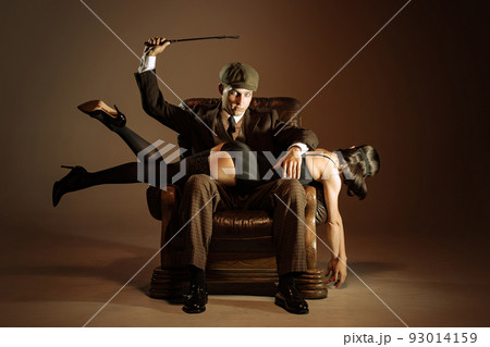 Creative portrait of man and woman in 1920s style fashion outfits isolated over dark brown background. Relationship, business, love, art, fashion Creative portrait of man and woman in 1920s style fashion outfits isolated over dark brown background. Relationship, business, love, art, fashion 93014159