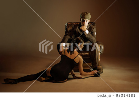 Vintage style portrait of man and woman in 1920s style fashion outfits isolated over dark brown background. Relationship, business, love, art, fashion Vintage style portrait of man and woman in 1920s style fashion outfits isolated over dark brown background. Relationship, business, love, art, fashion 93014181
