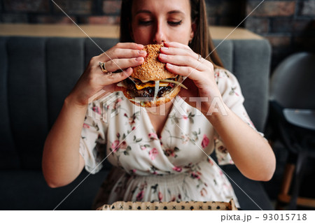 Hamburger girl eat. Pretty Young Happy Woman Eating Tasty Burger. Junk Food Concept. Hamburger girl eat. Pretty Young Happy Woman Eating Tasty Burger. Junk Food Concept. 93015718