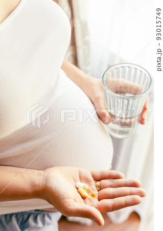 Pregnant woman pills vitamin. Happy smiling woman taking pill with supplement vitamin Omega 3. Vitamin D, E, A Fish Oil Capsules. Pregnant woman pills vitamin. Happy smiling woman taking pill with supplement vitamin Omega 3. Vitamin D, E, A Fish Oil Capsules. 93015749