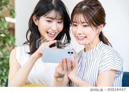 スマホでライブ配信を楽しむ二人の女性 93016447