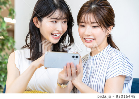 スマホでライブ配信を楽しむ二人の女性 93016448